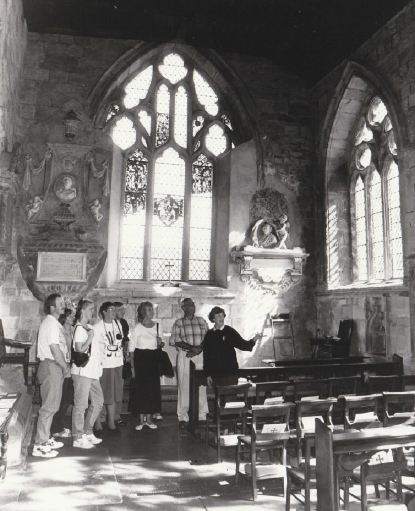 CHURCH: Guide Joyce Perry showing visitors around Cartmel Priory in 1995